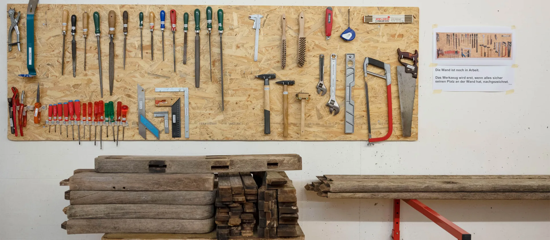 Eine Werkzeugwand, an der viele Werkzeuge ordentlich aufgehängt sind.